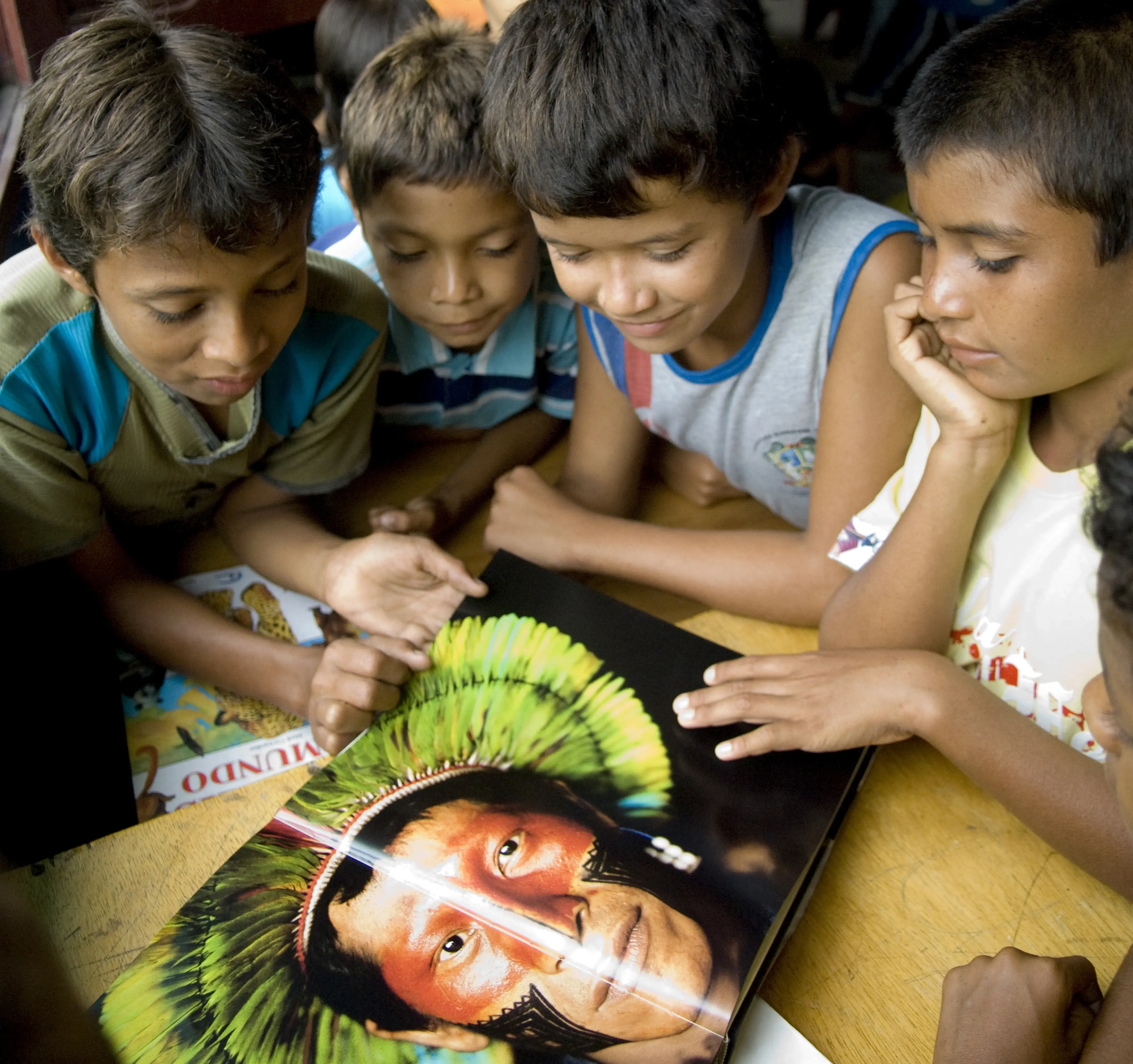 Children around the image of an indigenous person at a table