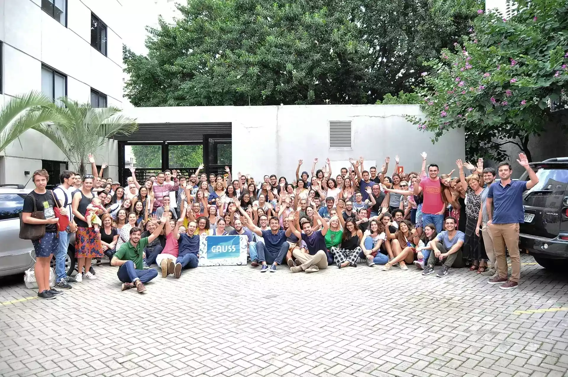 Dezenas de pessoas posando para uma foto no pátio para o evento Família Gauss no pátio do Projeto Gauss